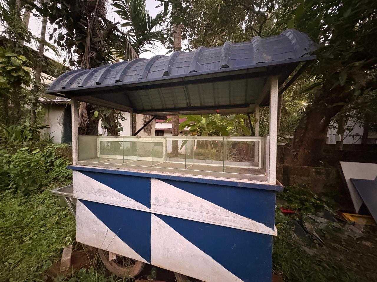 The original blue-and-white mobile shop photographed outdoors in Kerala